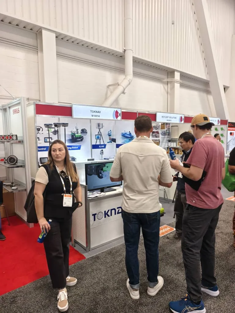 Busy exhibition booth with international visitors